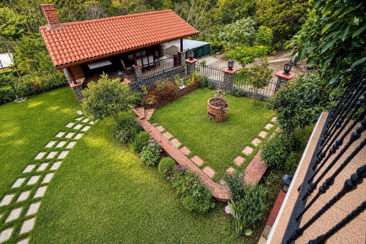 Vista aérea del jardín con senderos de ladrillo, fogata y ramada de teja